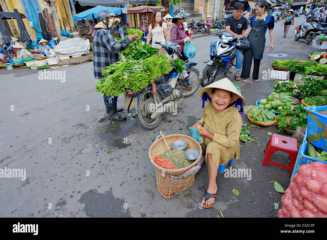 Woman selling fresh herbs and spices at market in Hoi An, Vietnam. Stock Photo
