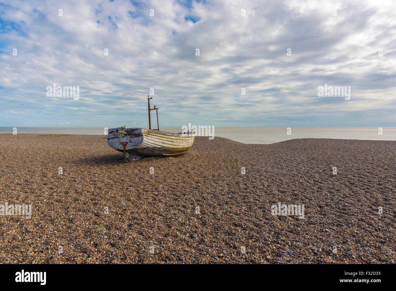 Fishing boat sitting on a shingle beach Stock Photo - Alamy