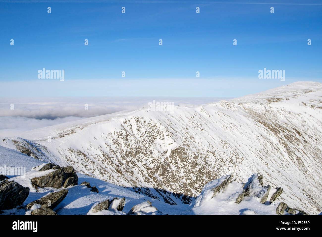 View from Pen yr Ole Wen to Carnedd Dafydd with walkers on ridge in Carneddau mountains of Snowdonia in winter. North Wales, UK Stock Photo