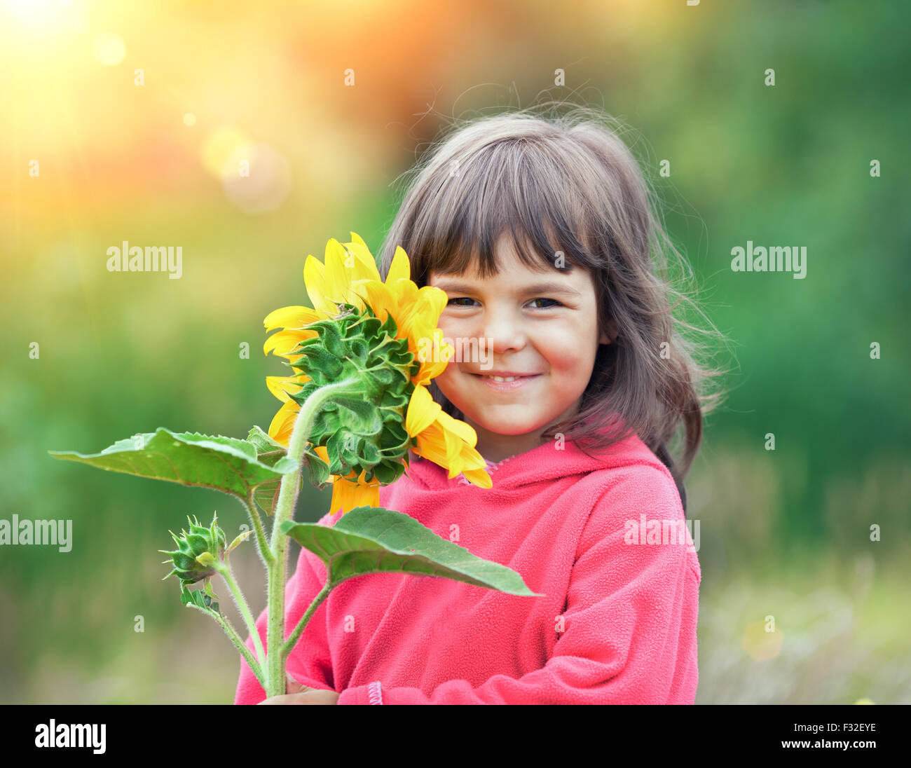 Little girl with sunflower outdoors Stock Photo - Alamy