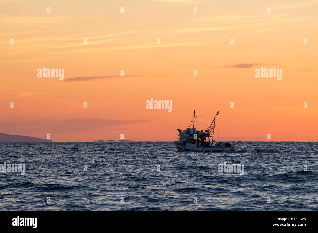 Fishing boat in sunset sea hi-res stock photography and images - Alamy