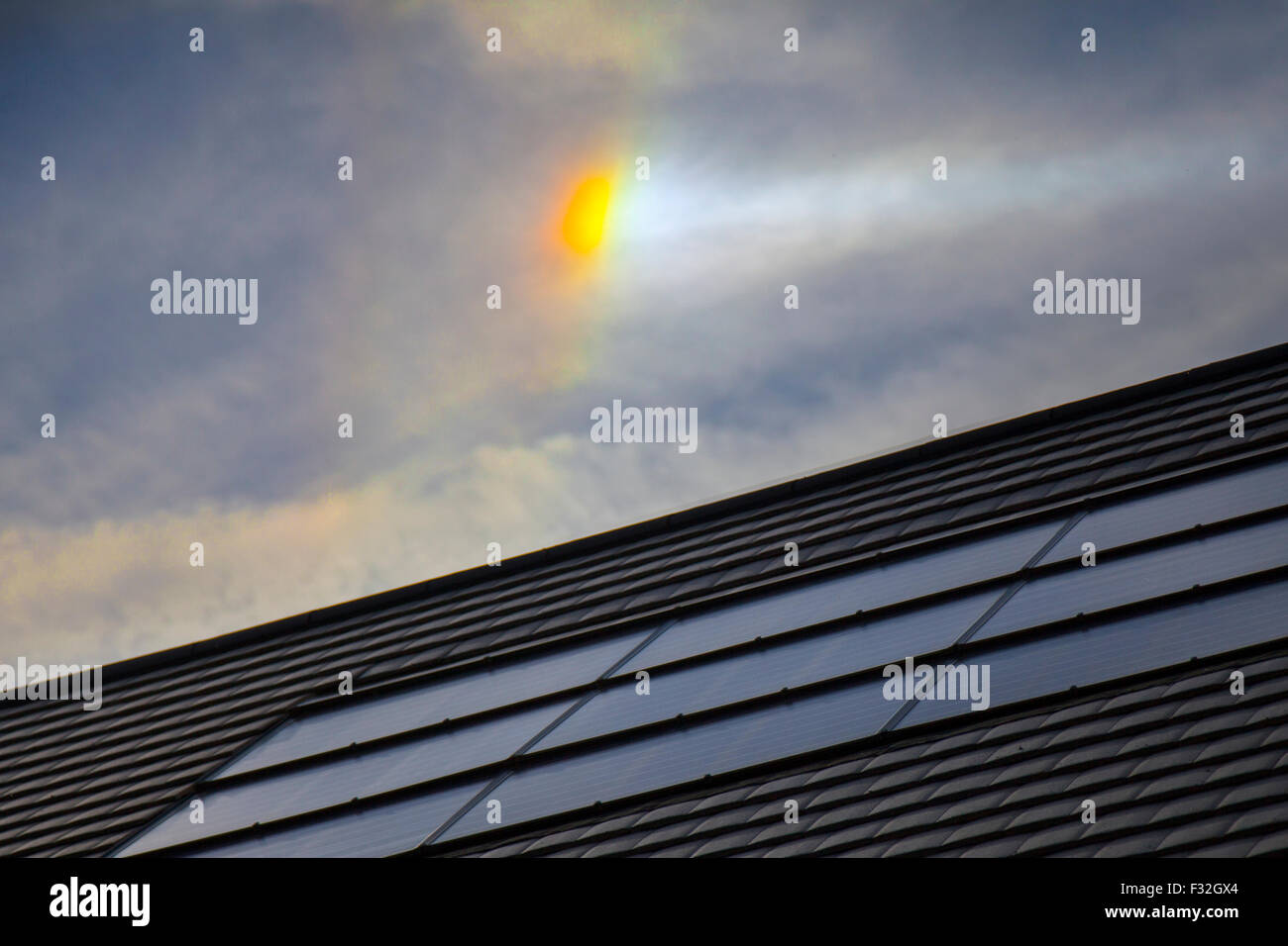 Chorley, Lancashire, UK. 28th September, 2015. UK Weather: Optical phenomena over roof with solar panel. The circumzenithal and circumhorizontal arcs are two related optical phenomena similar in appearance to a rainbow, but unlike the latter, their origin lies in light refraction through hexagonal ice crystals rather than liquid water droplets. This means that they are not rainbows, but members of the large family of halos. Credit:  Cernan Elias/Alamy Live News Stock Photo