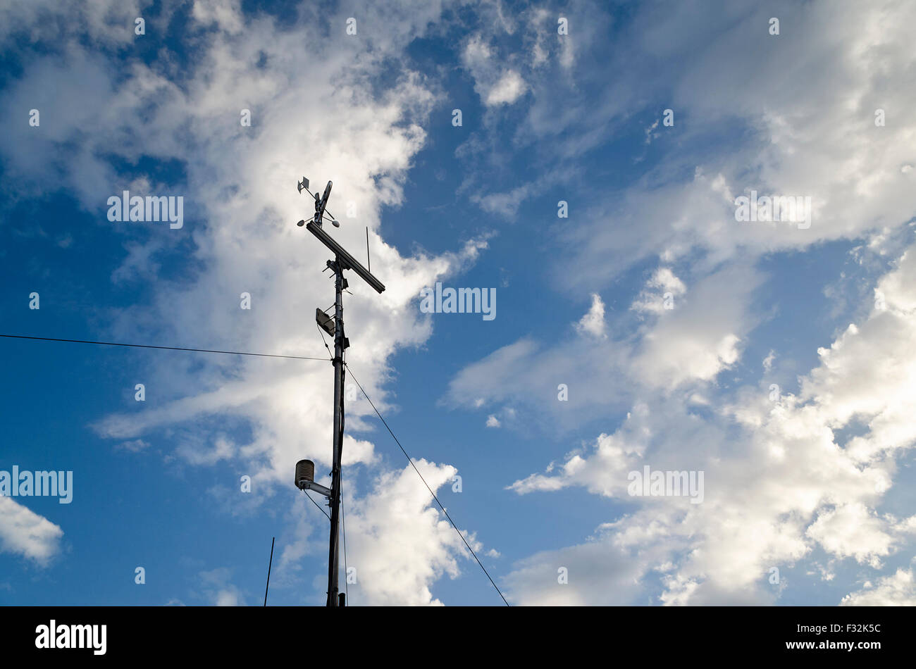 Anemometer and wind vane on blue sky Stock Photo