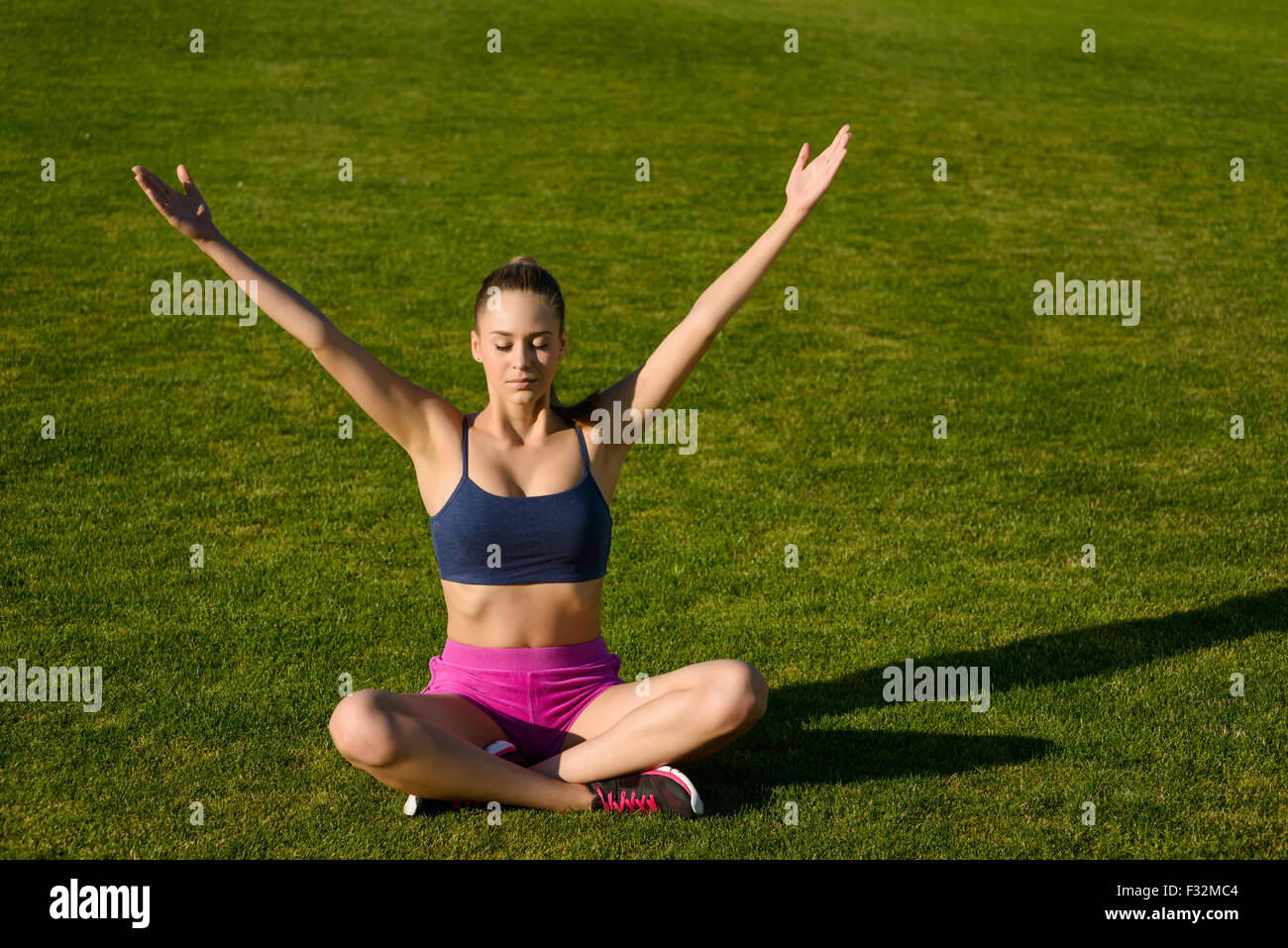Girl doing yoga sitting on the grass Stock Photo - Alamy