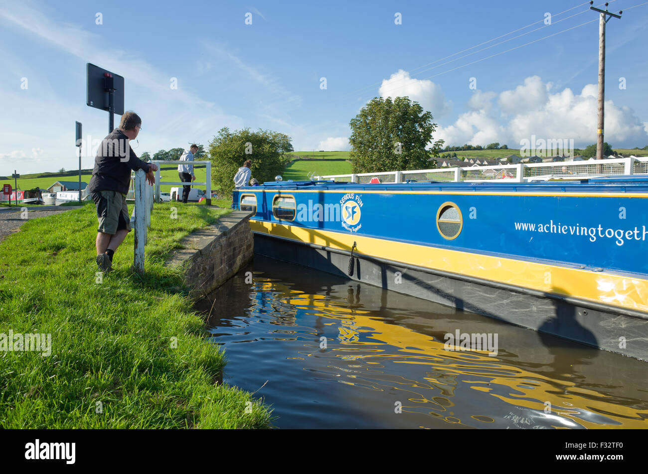 Canal boat passing through open swing bridge Stock Photo
