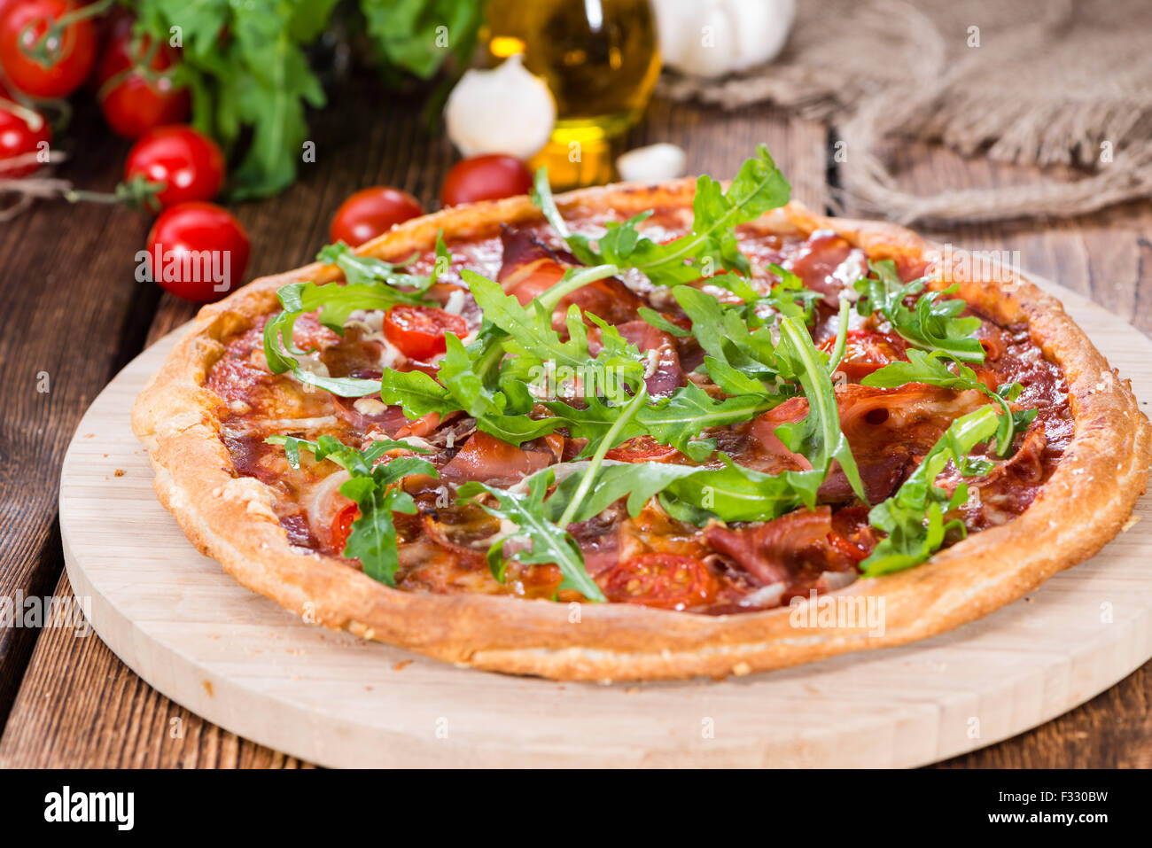 Ham Pizza with rocket, fresh tomatoes, garlic and cheese Stock Photo