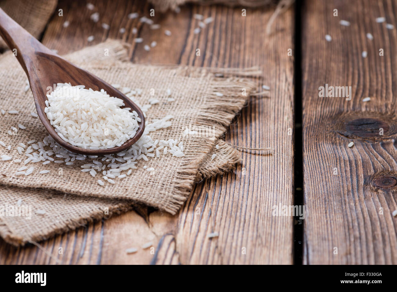 Heap of uncooked Rice (close-up shot) on wooden background Stock Photo ...