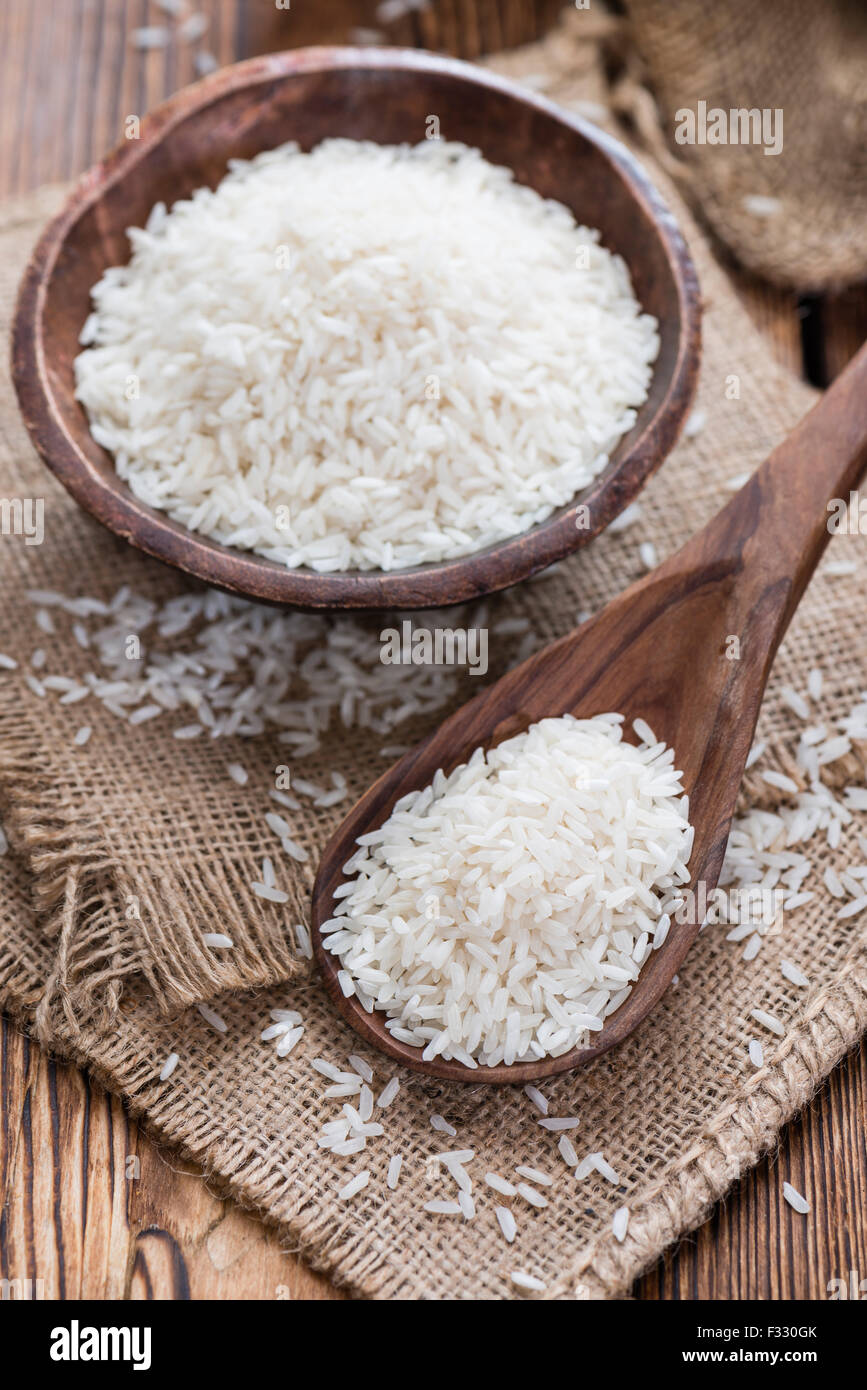 Heap of uncooked Rice (close-up shot) on wooden background Stock Photo ...