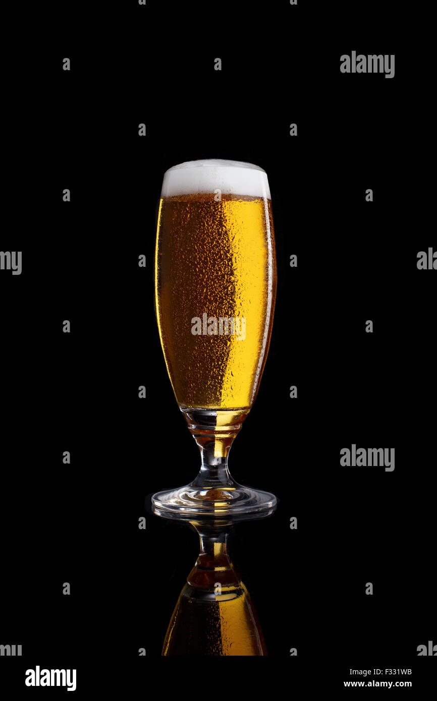 Glass of light beer isolated on a black background. Stock Photo