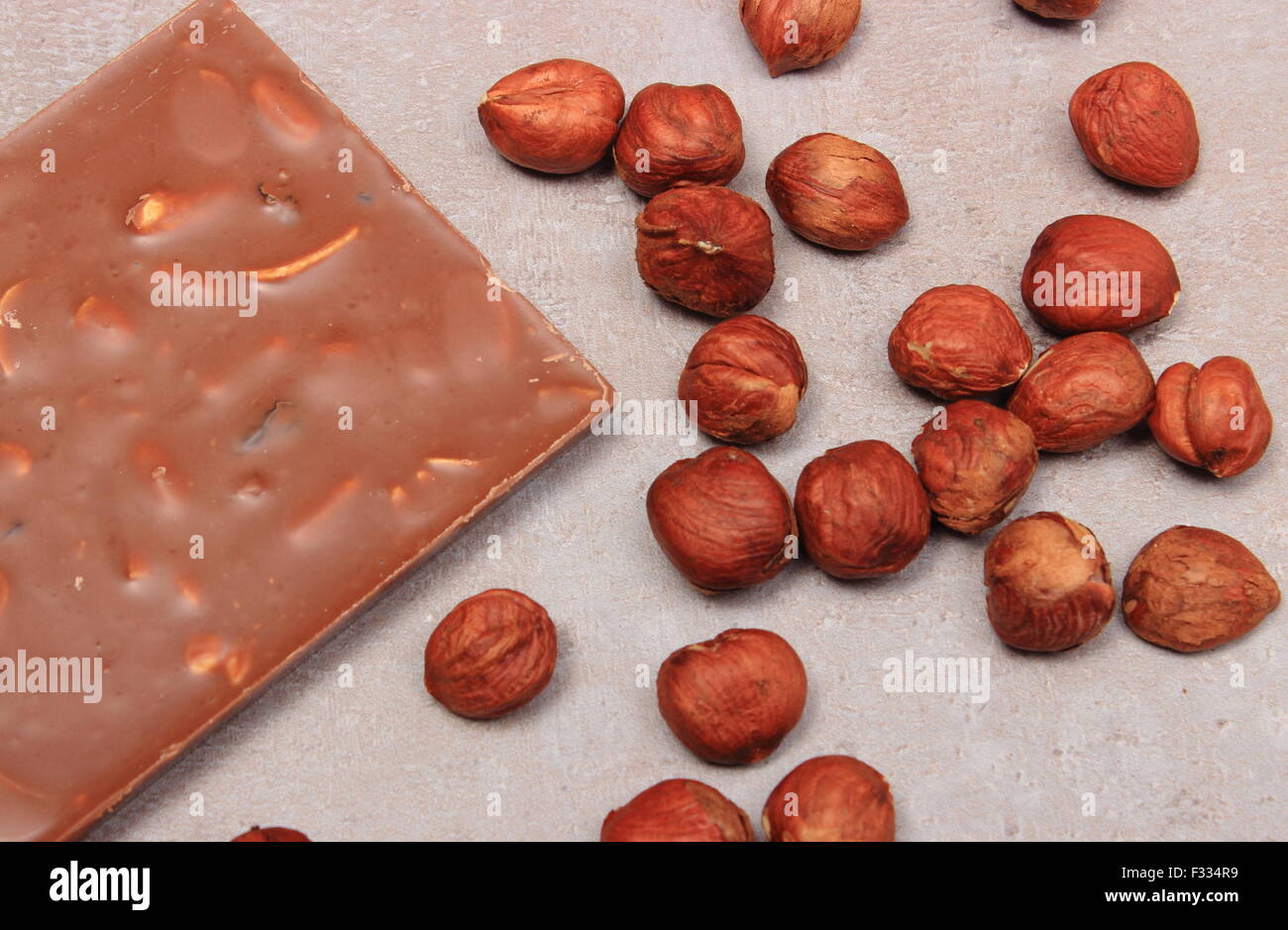 Nutritious chocolate and hazelnuts on structure of gray concrete Stock