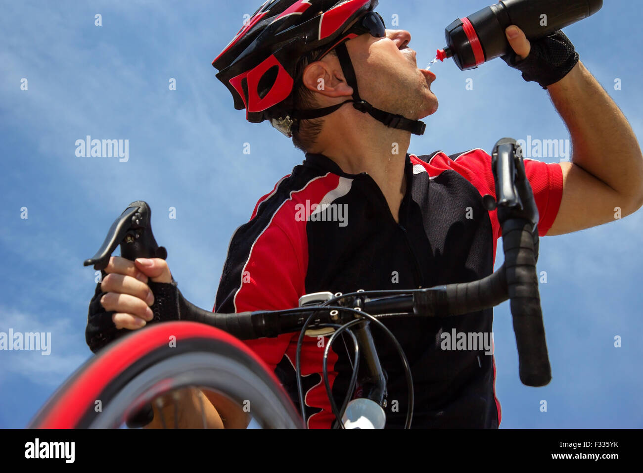 cyclist drinking from a bottle while riding a bike Stock Photo