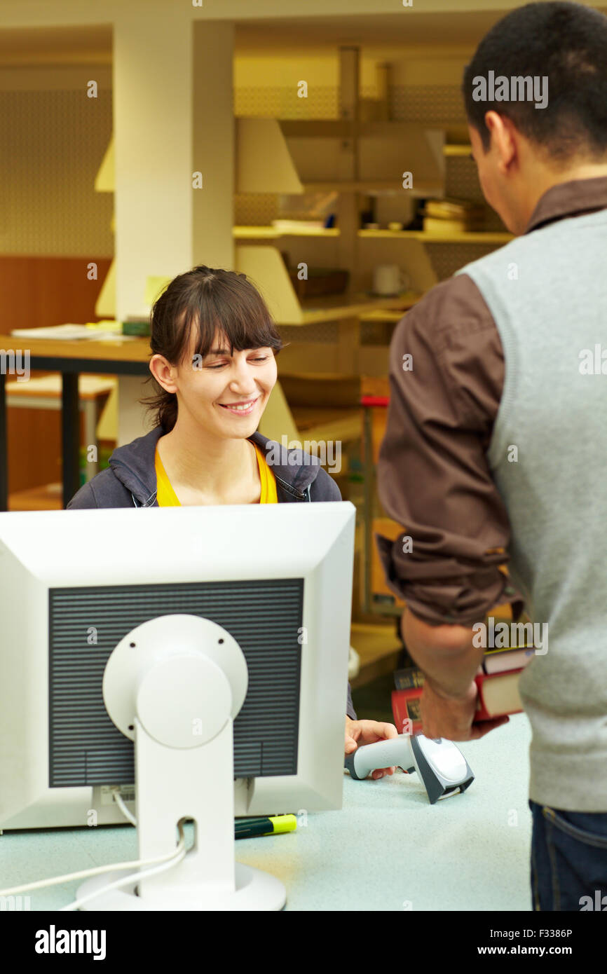 Student renting books at university library checkout Stock Photo Alamy