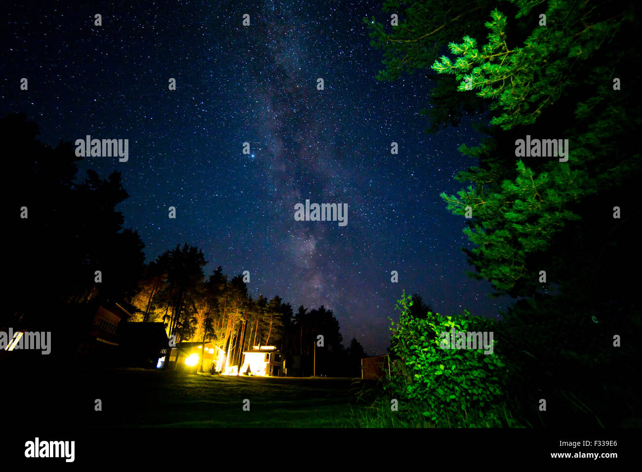 Night starry sky scene with milky way and lights of cottages Stock ...