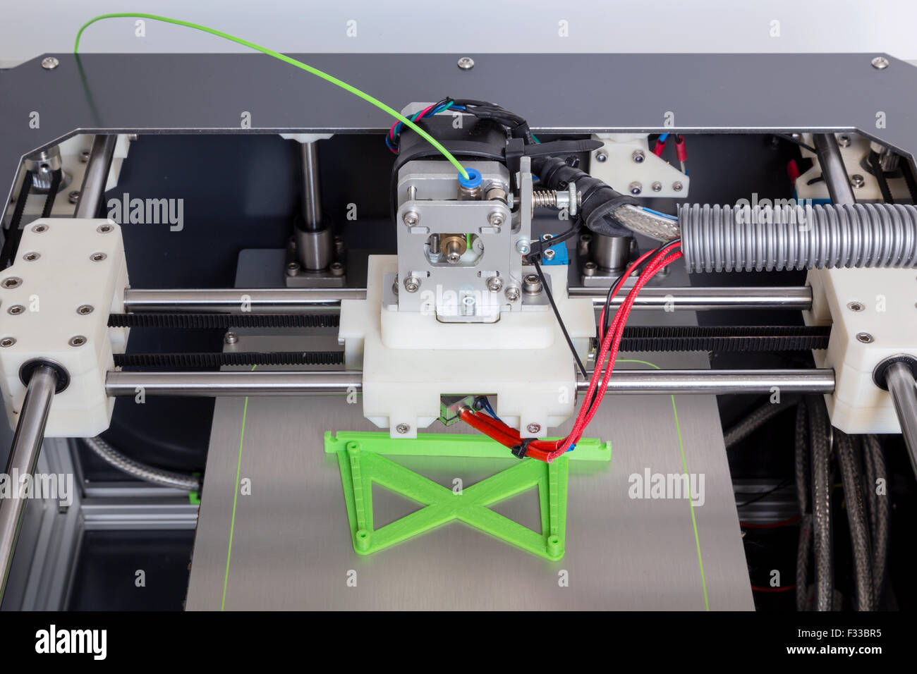 3d printer with bright green filament. Stock Photo