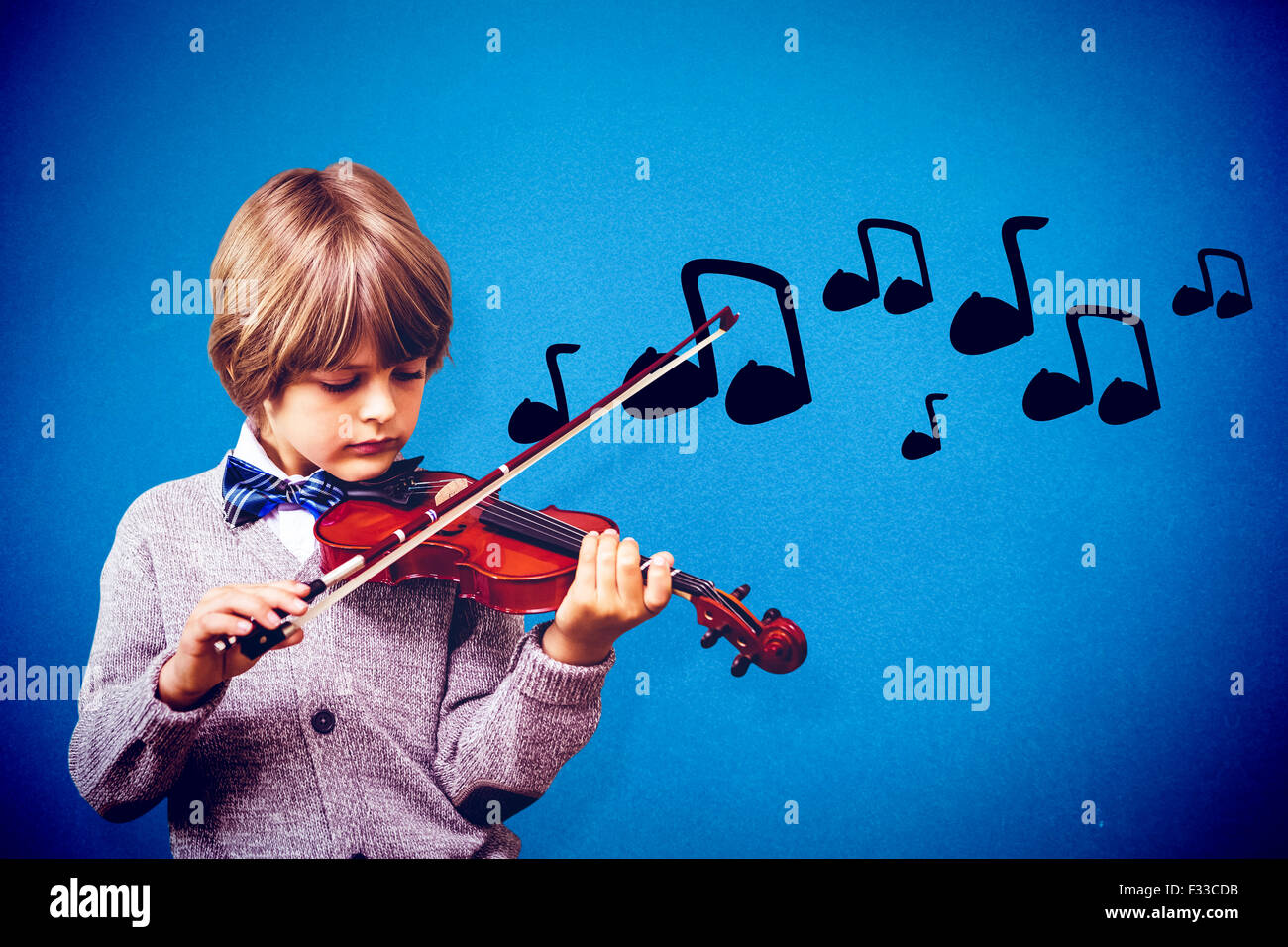 Composite image of cute little boy playing violin Stock Photo