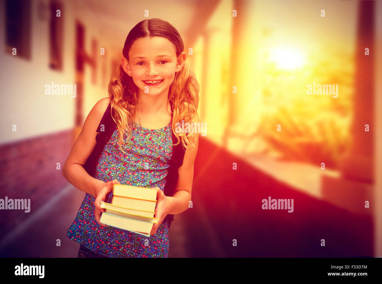 Composite image of cute little girl holding books in library Stock ...