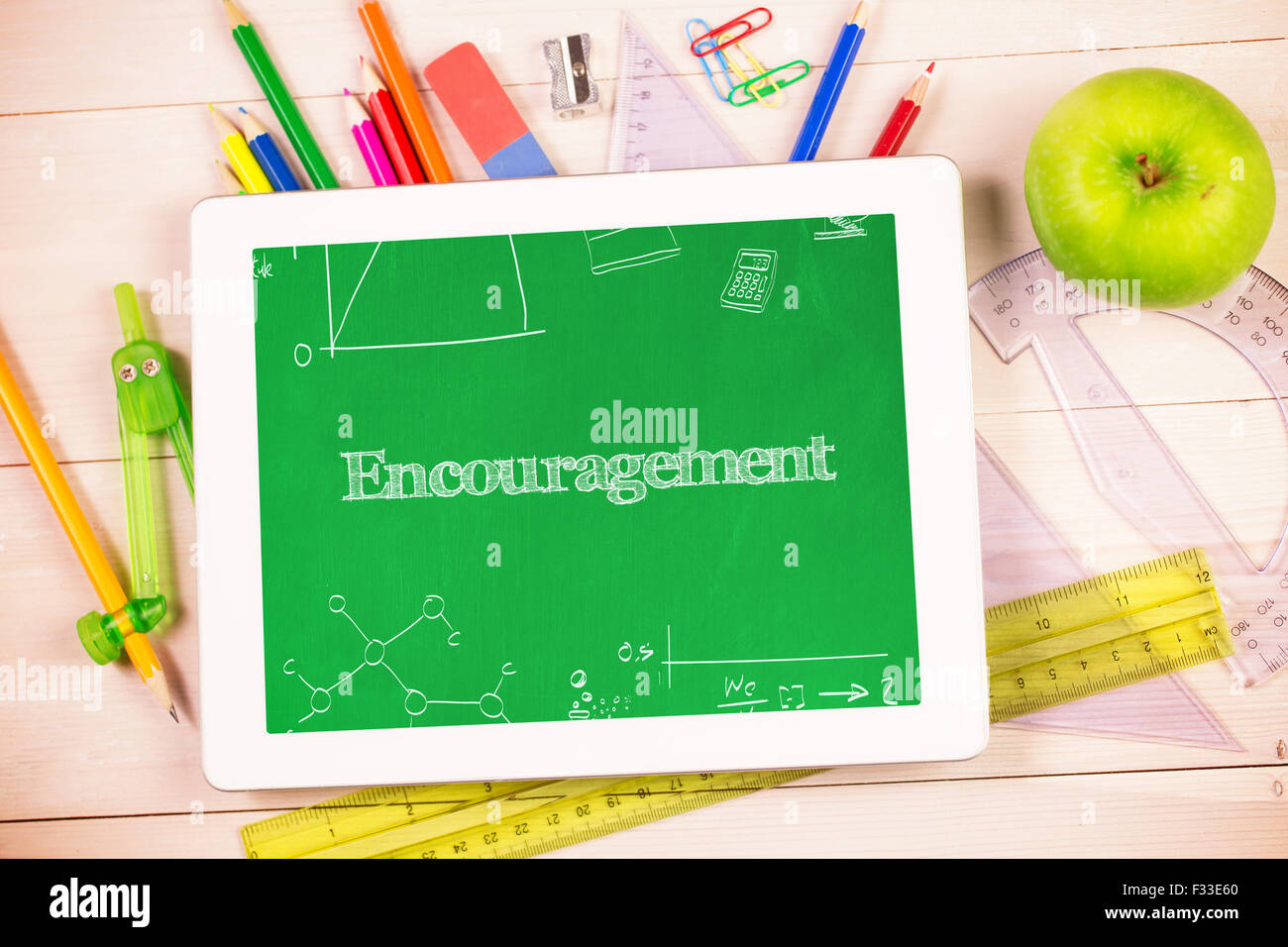 Encouragement against students desk with tablet pc Stock Photo