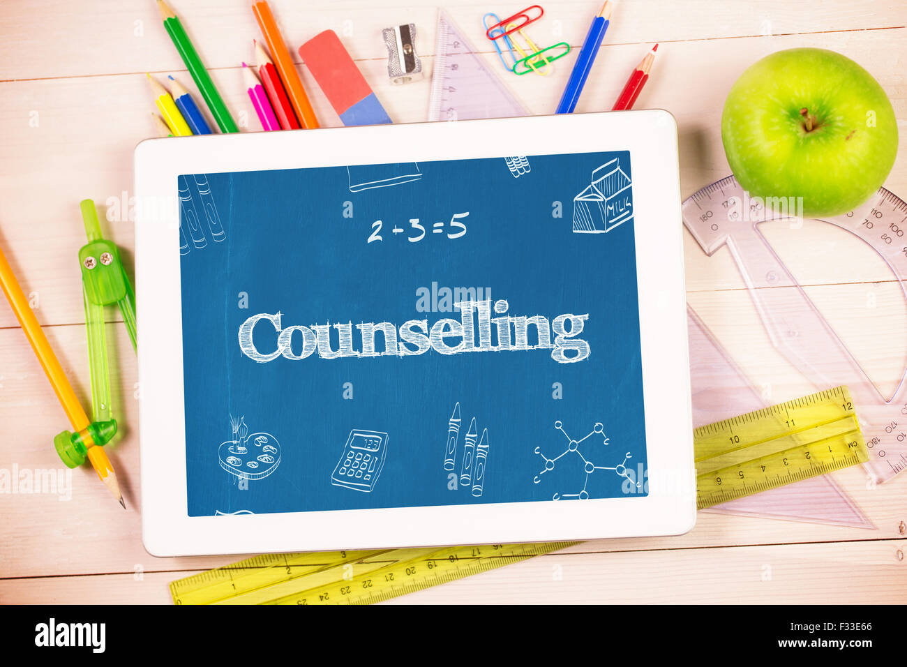 Counselling against students desk with tablet pc Stock Photo