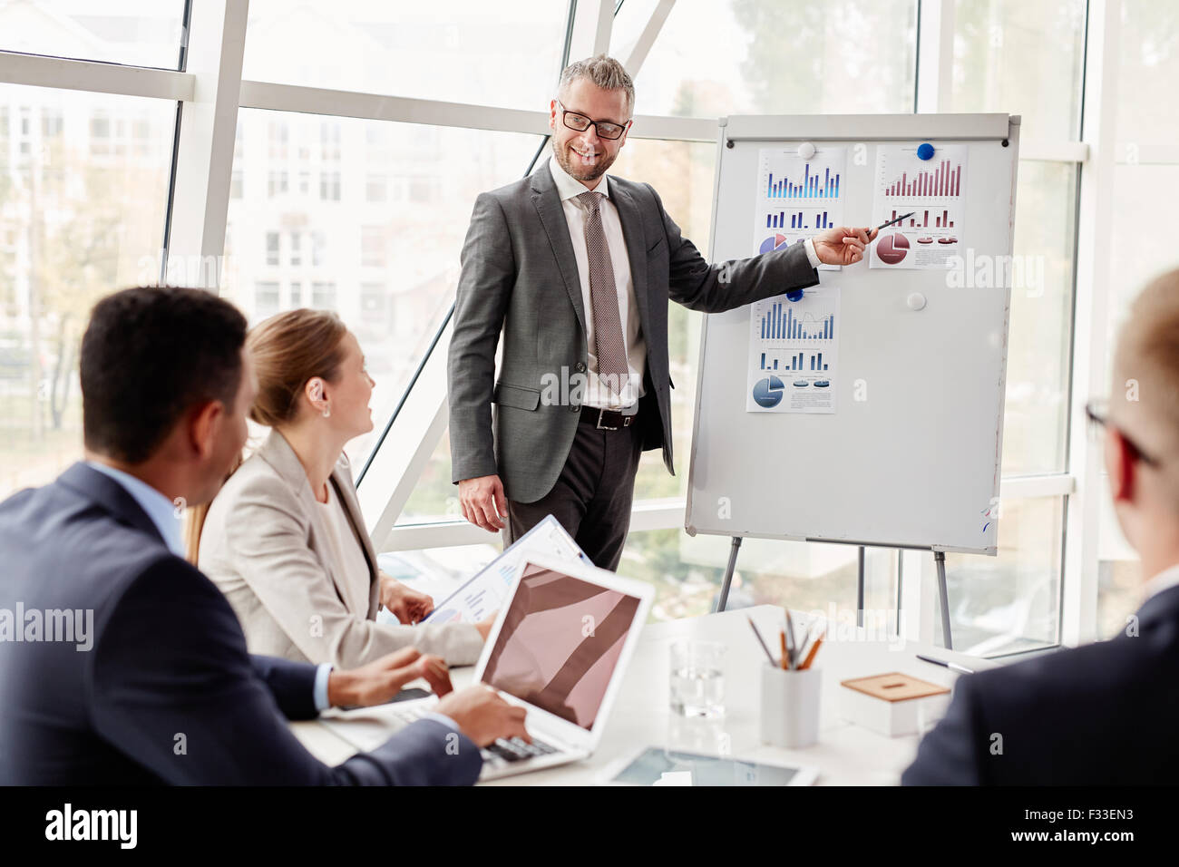 Experienced businessman by whiteboard explaining situation on the ...