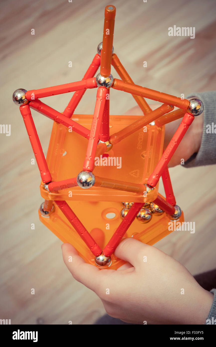 A young child holding a geometric toy. Stock Photo