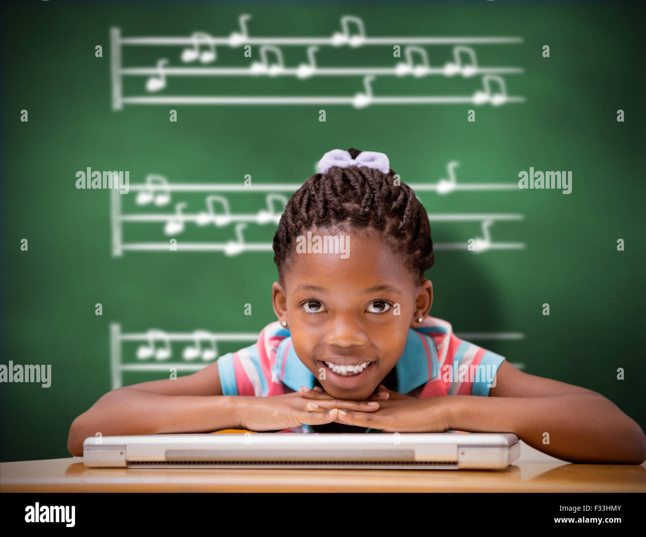 Composite image of smiling pupil sitting at her desk Stock Photo - Alamy