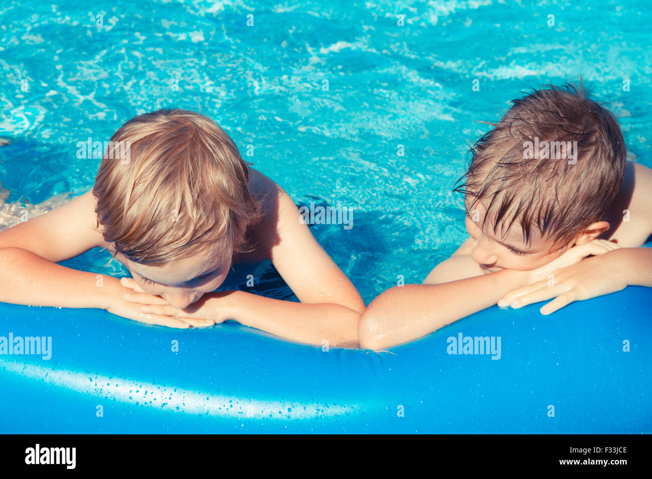 Two young boys outdoors playing in inflatable pool. Stock Photo