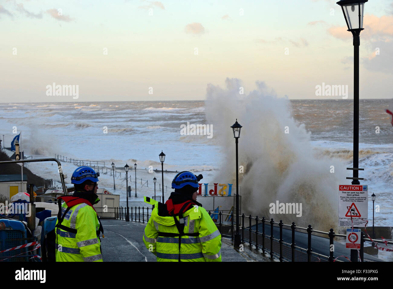 Coastguard assessing  damsage along Cromer Promenade Norfolk at dawn after storm surge Dec 2013 Stock Photo