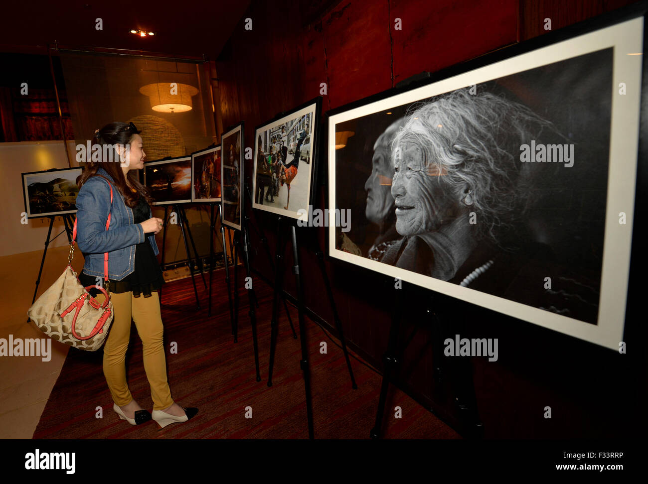 Lhasa, China's Tibet Autonomous Region. 29th Sep, 2015. A visitor looks at photo works at a photography exhibition of Tibet in Lhasa, capital of southwest China's Tibet Autonomous Region, Sept. 29, 2015. The exhibition will last till Oct. 7. Credit:  Liu Dongjun/Xinhua/Alamy Live News Stock Photo