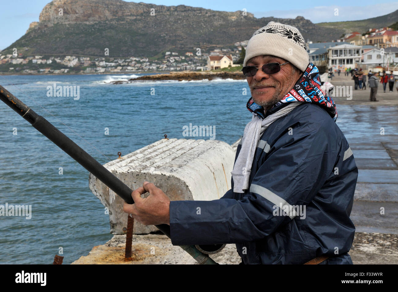 Man fishing off Kalk Bay harbour wall Stock Photo