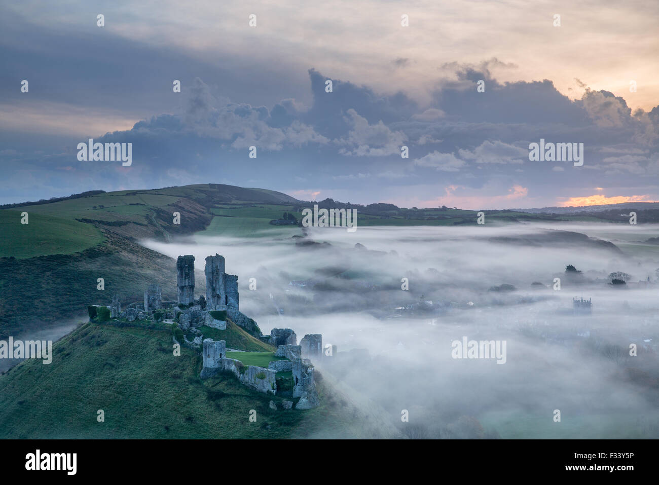 Corfe Castle in the mist at dawn, Dorset, England, UK Stock Photo