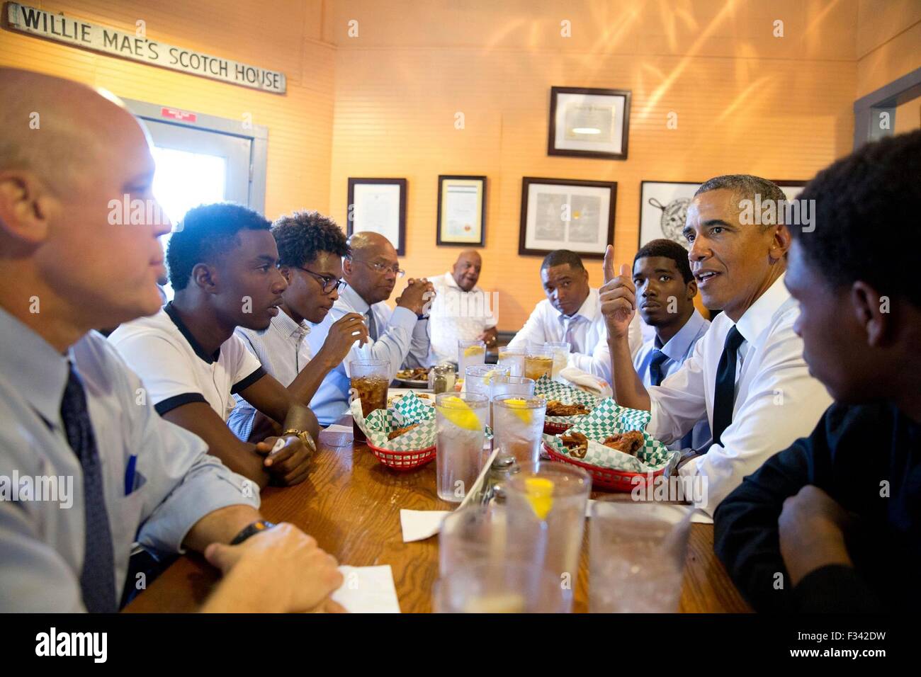 U.S. President Barack Obama talks with young men during a lunch stop with them at Willie Mae's Scotch House August 27, 2015 in New Orleans, Louisiana. The president is visiting New Orleans to mark the tenth anniversary of Hurricane Katrina. Stock Photo