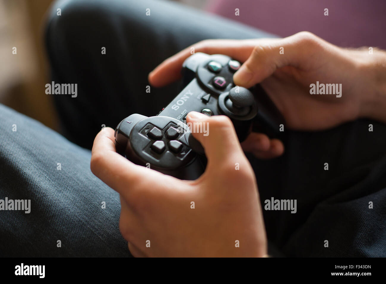 A man using a wireless controller to play a computer game.  Ian Hinchliffe / ianrichardhinchliffe.co.uk Stock Photo