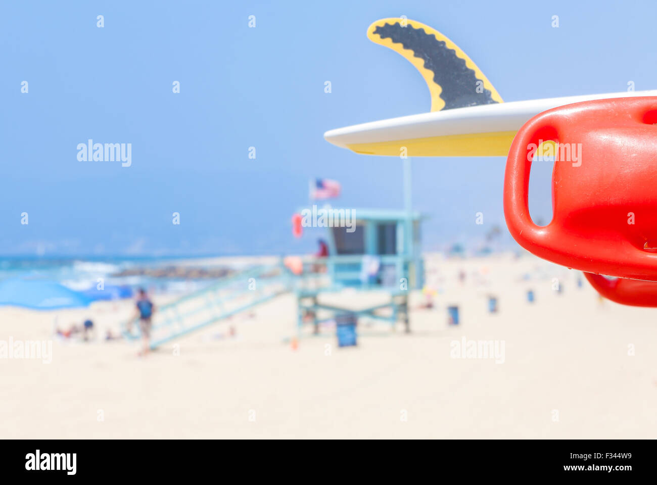 Lifeguard red buoy on a beach with lifeguard tower in distance, shallow depth of field, space for text, California, USA. Stock Photo