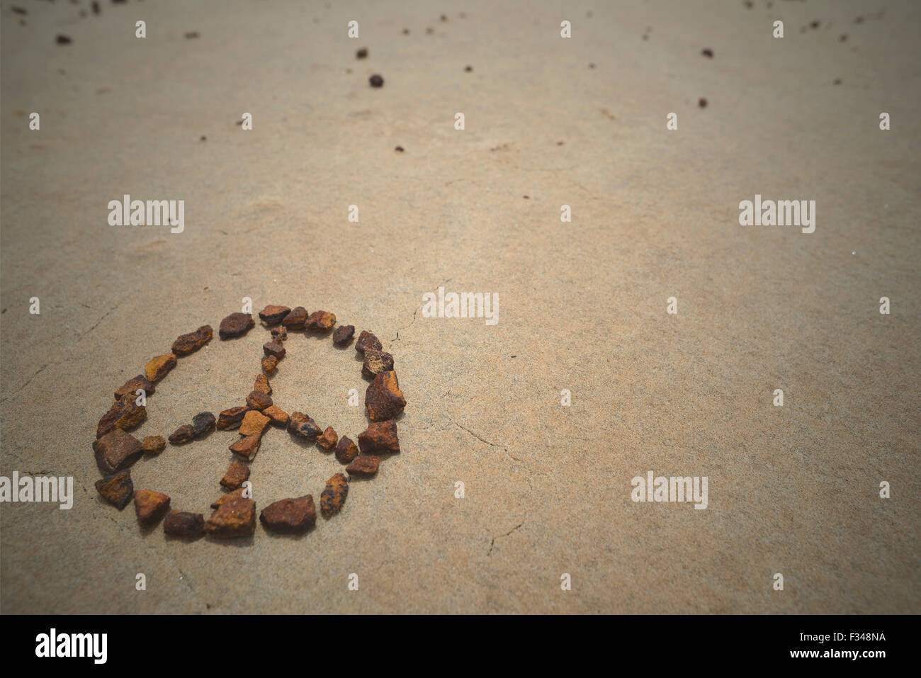 Peace symbol made with rocks on beach sand. Summer hipster background. Stock Photo