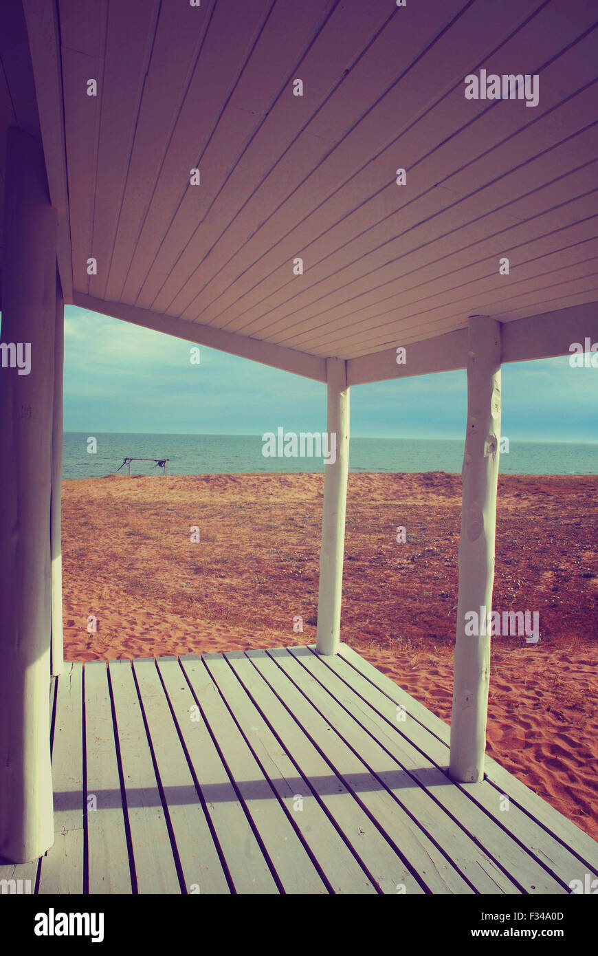 White beach house porch with vintage style filter effect and ocean view background. Stock Photo