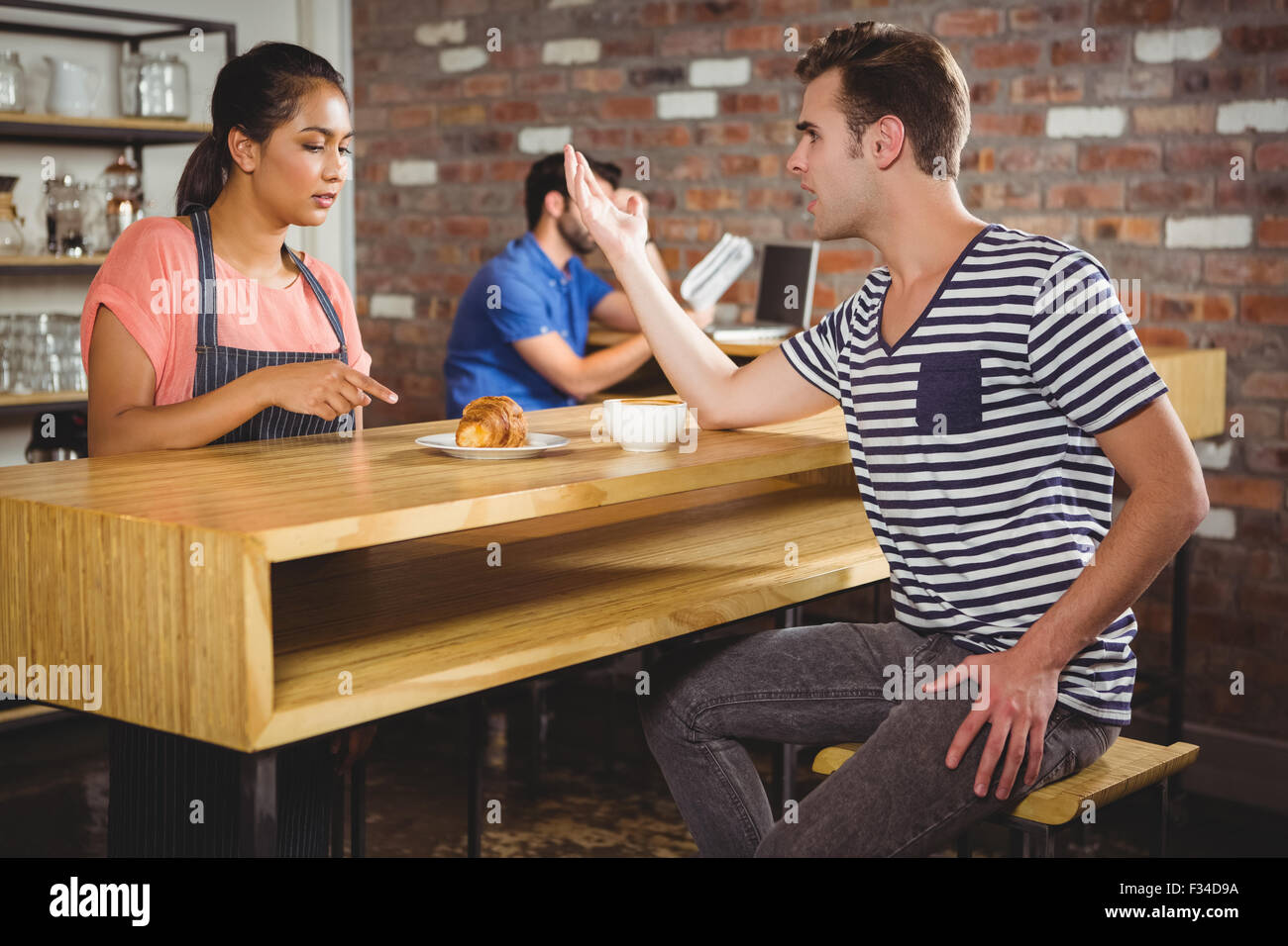 Unhappy customer complaining about the croissant Stock Photo
