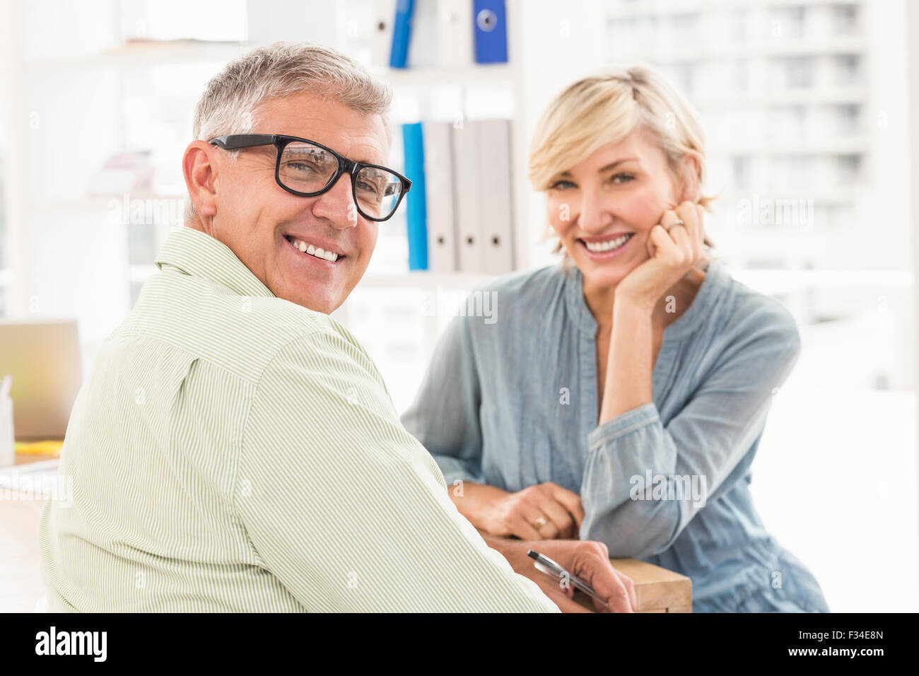 Smiling business team looking at the camera Stock Photo - Alamy