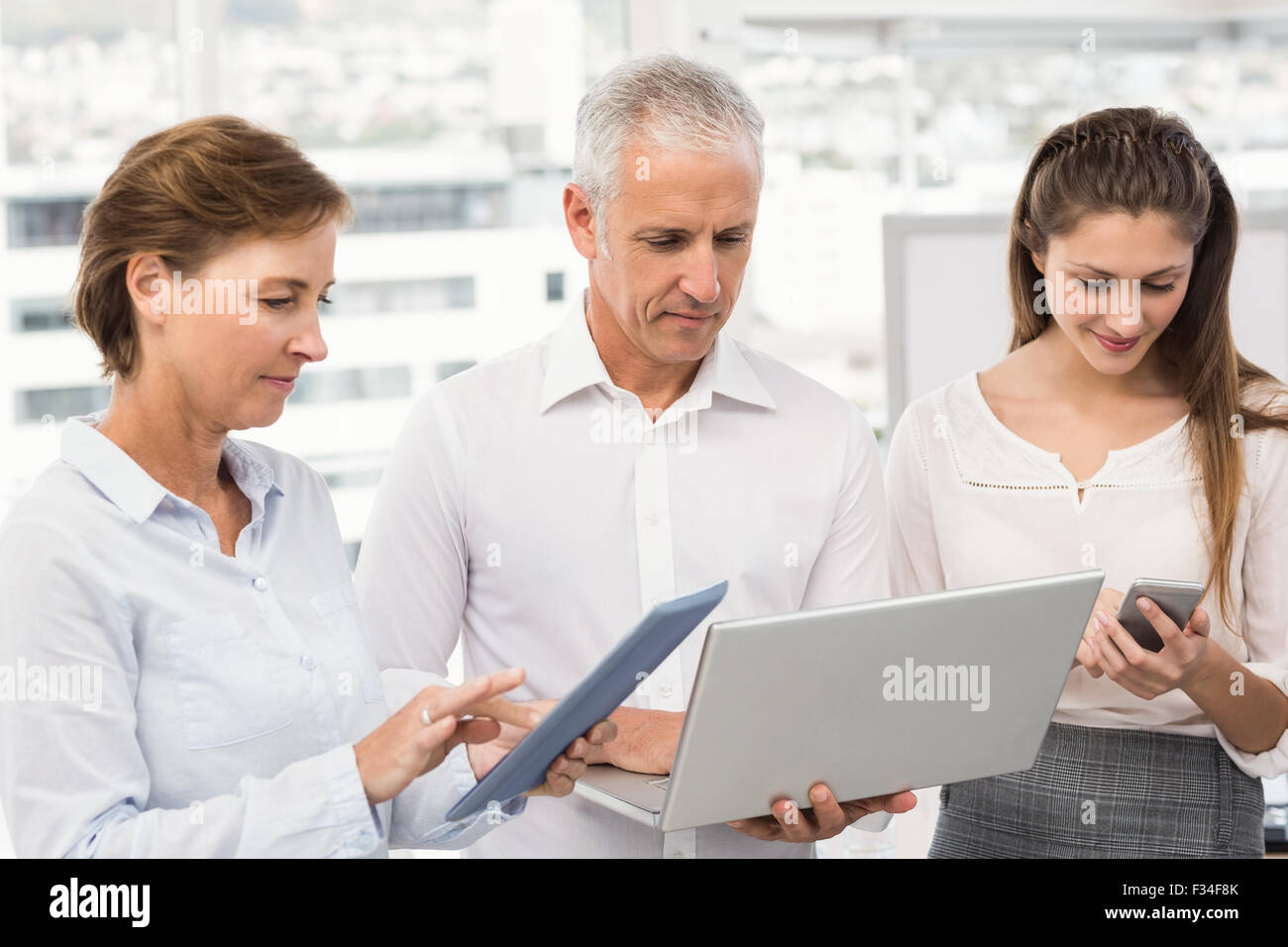 Business people using several electronic devices Stock Photo Alamy