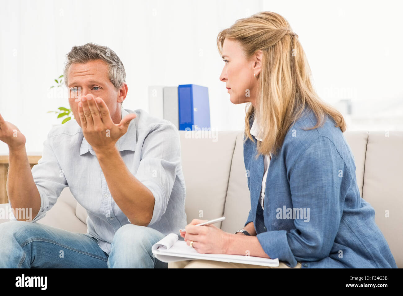 Therapist listening to male patients worries Stock Photo