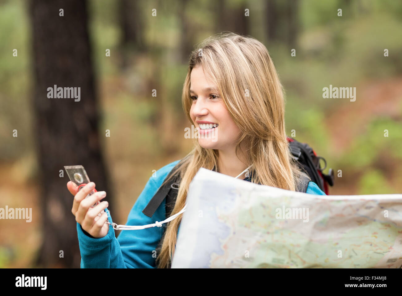 Young pretty hiker using compass and map Stock Photo - Alamy