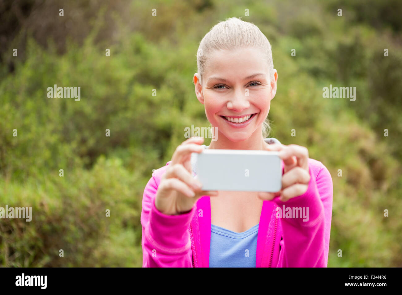 Smiling female hiker taking a selfie Stock Photo - Alamy