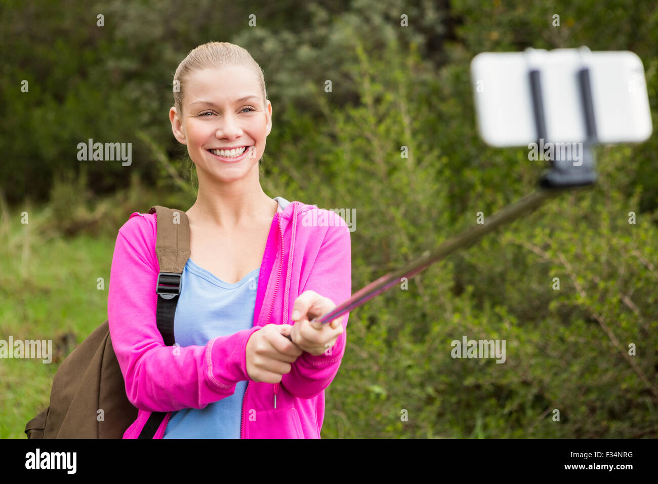 Smiling female hiker taking a selfie Stock Photo - Alamy