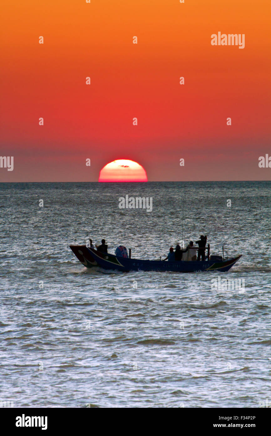 fishboat running at sunset over Pacific Ocean Stock Photo