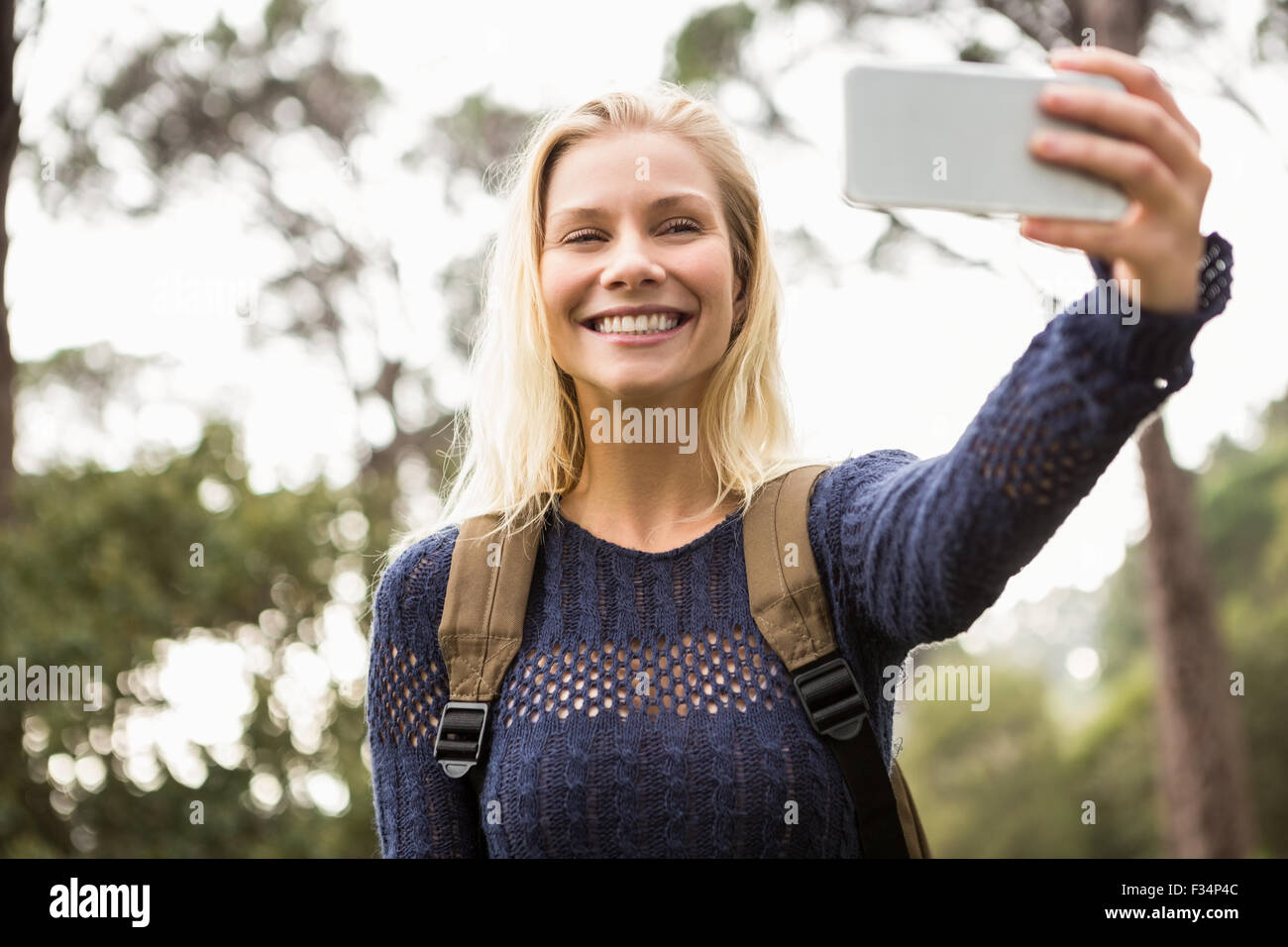 Smiling female hiker taking a selfie Stock Photo - Alamy
