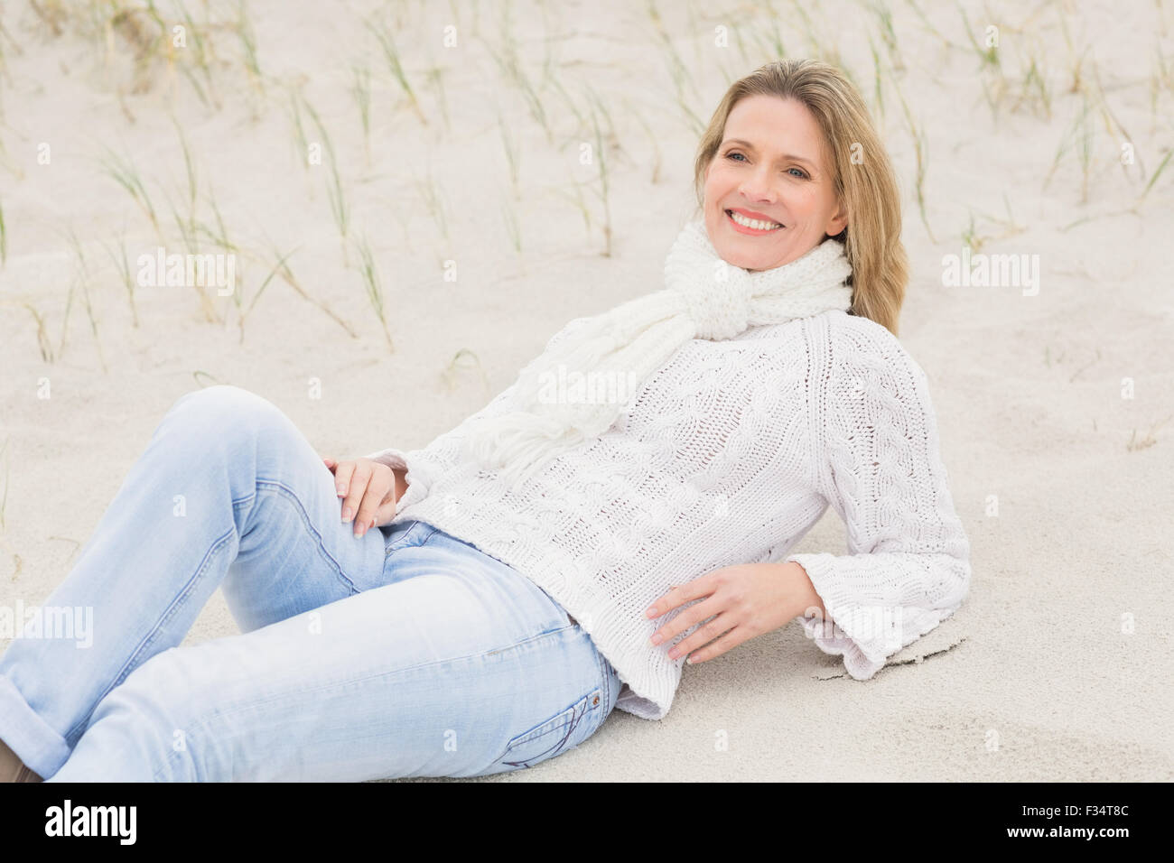 Woman lying down on the sand Stock Photo - Alamy