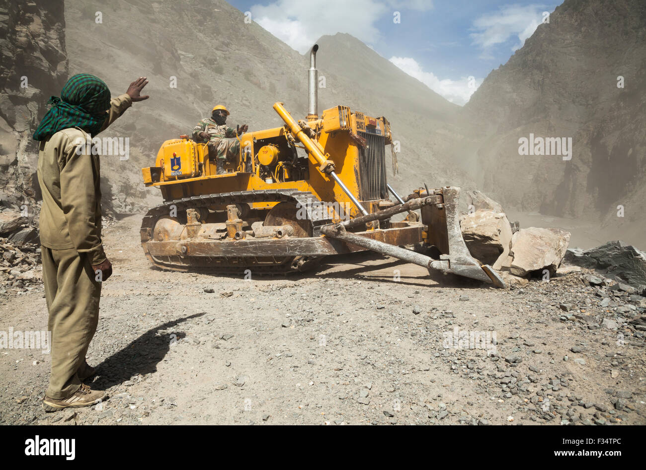 Bulldozer from Border Roads Organization and GREF clears hazardous Himalayan mountain road following landslide Stock Photo