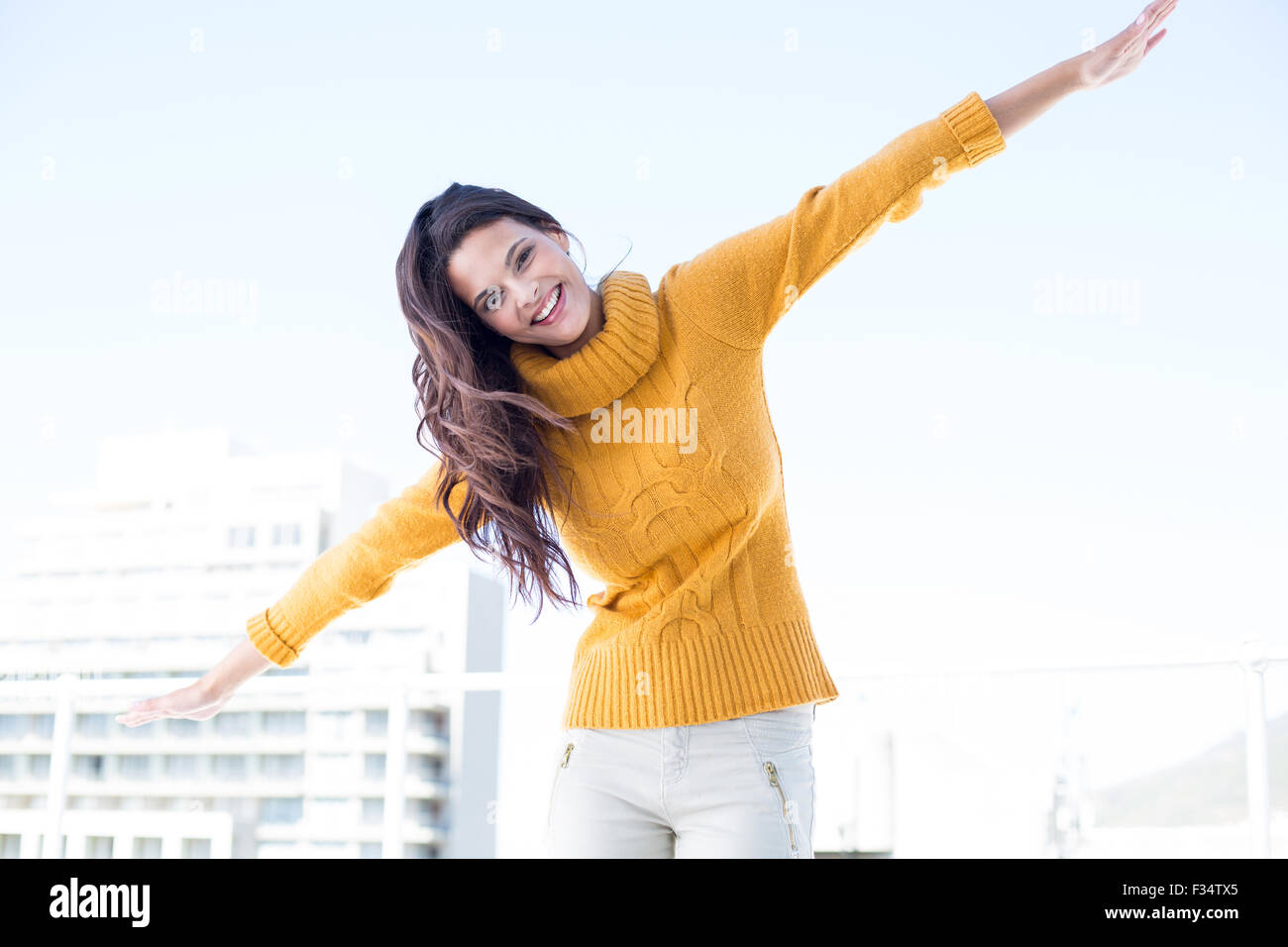 Happy woman looking camera with arms raised on Stock Photo