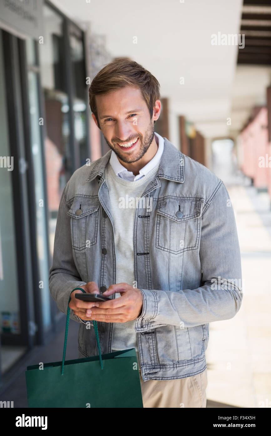 Young happy smiling man holding shopping bags and his mobile Stock ...