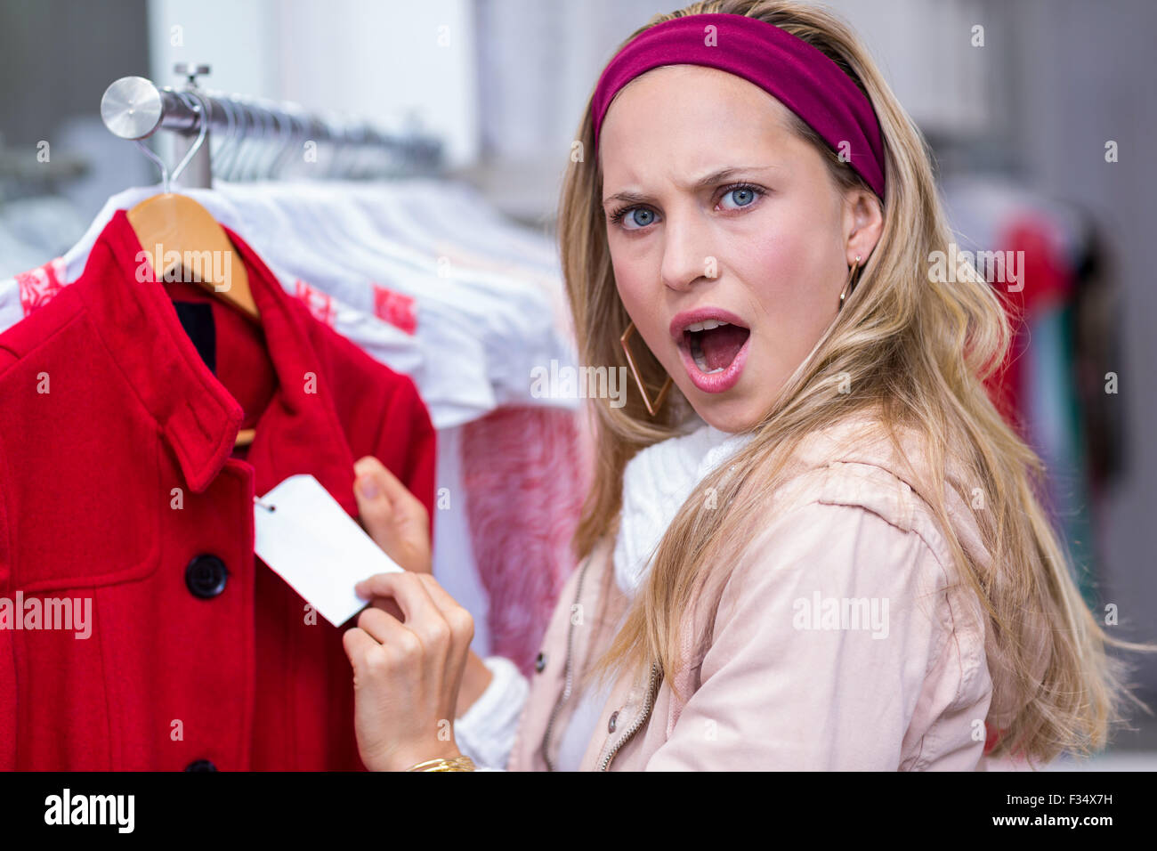 Shocked woman showing price tag to camera Stock Photo