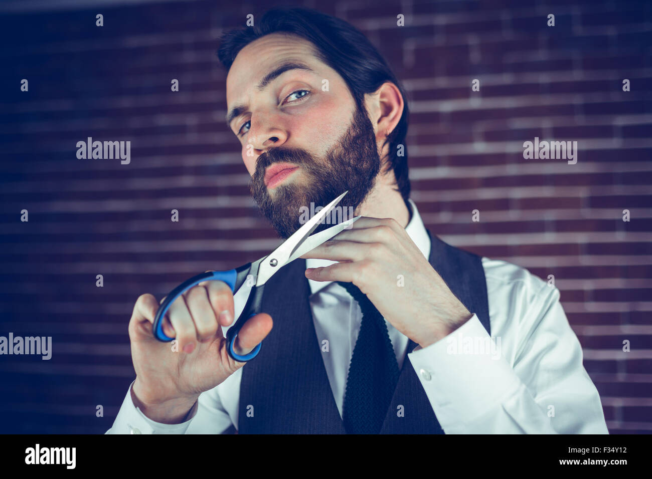 Portrait of man holding cutting beard with scissors Stock Photo Alamy